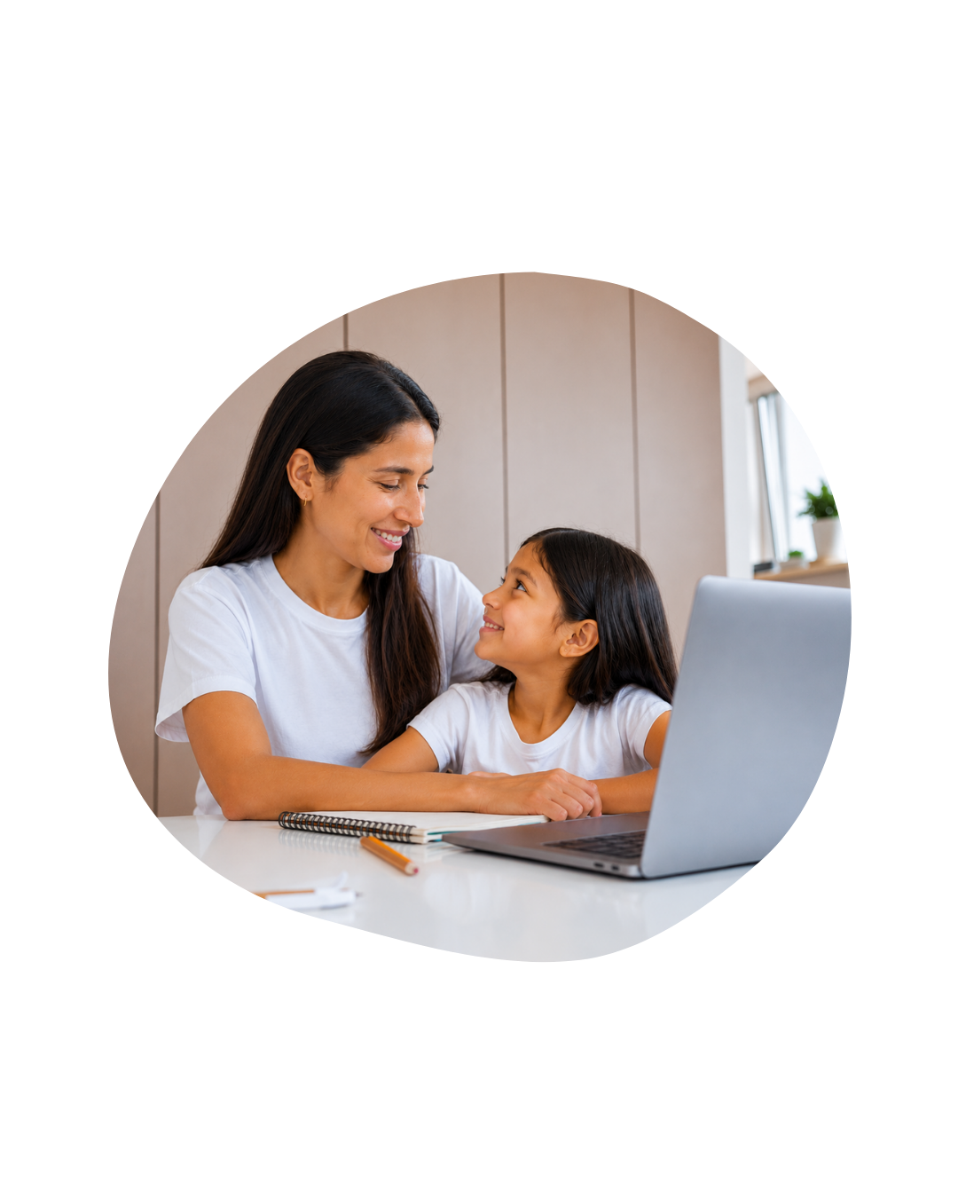 Madre acompañando a su hija durante una clase virtual de inglés para niños desde casa.